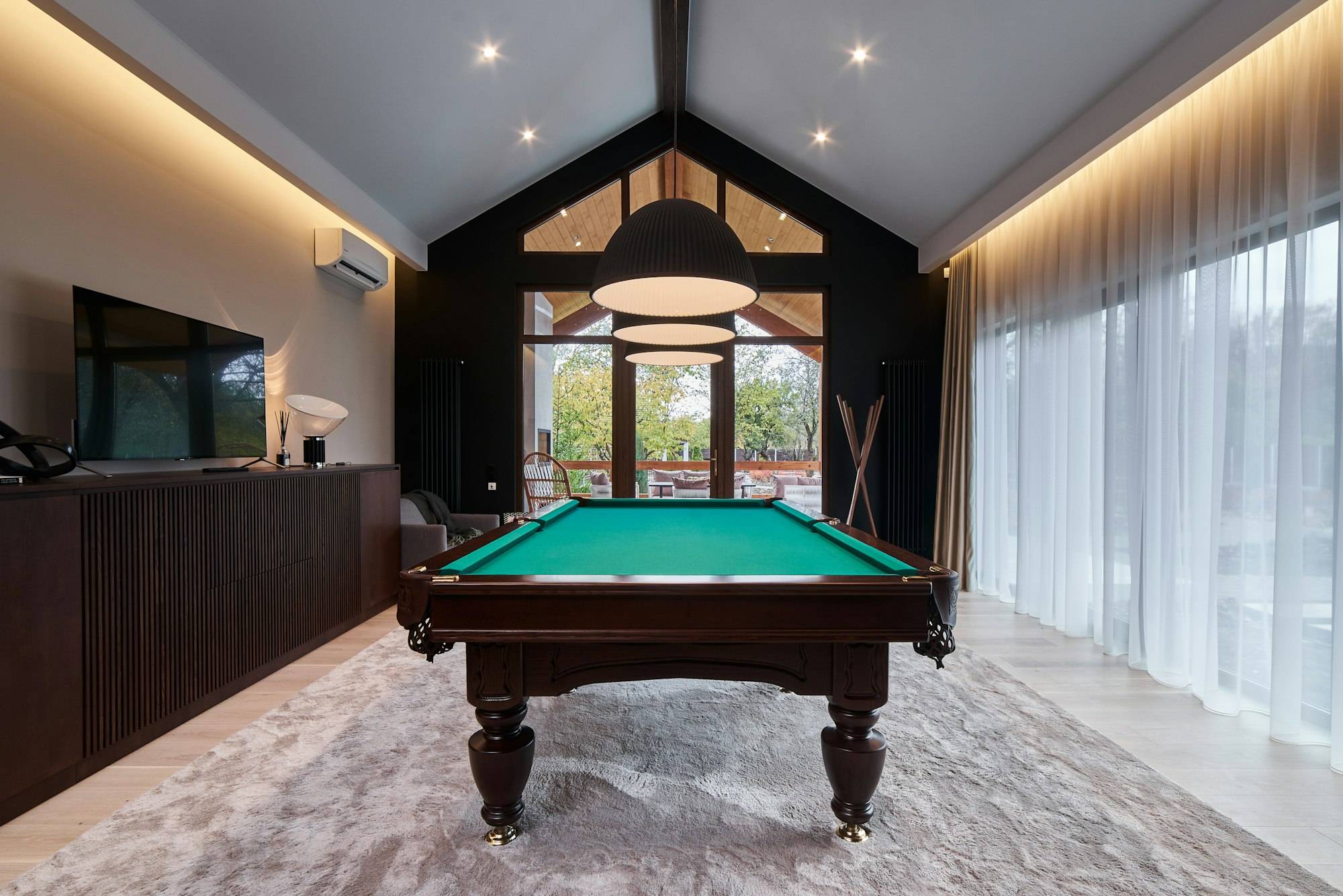 modern billiard room with a beautiful table and large windows